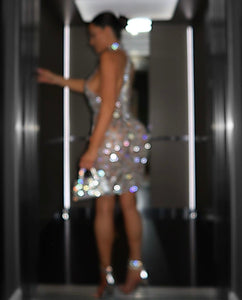 a woman in a silver dress standing in a doorway